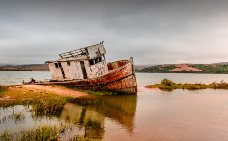 brown and white boat parked on islet